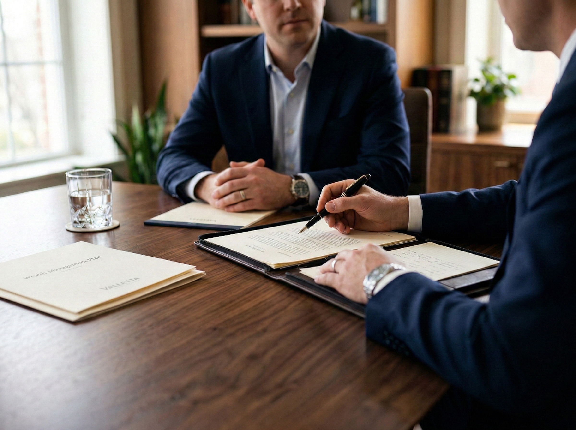 Private wealth consultation — Valletta Wealth advisors reviewing documentation with client